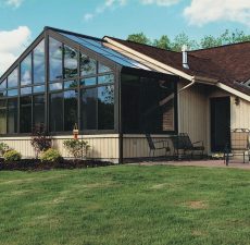 Glass cathedral sunroom next to a patio