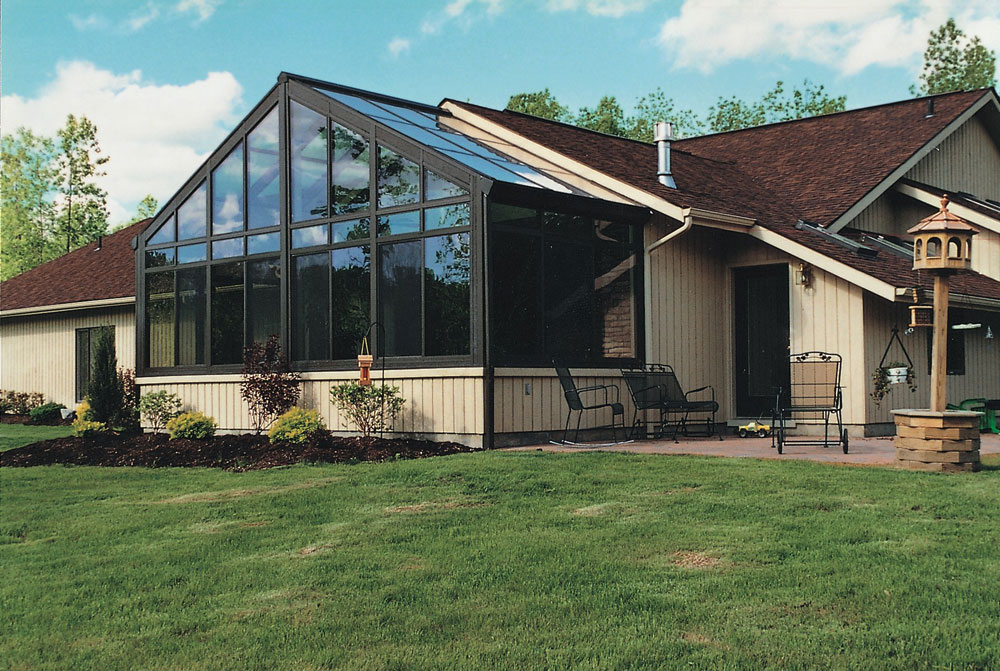 Glass cathedral sunroom next to a patio