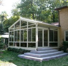 Glass cathedral sunroom with cement steps to outside
