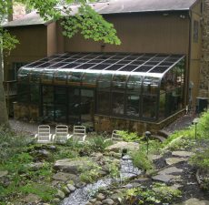 Curved eave sunroom with a pond view