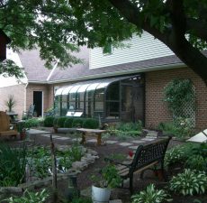 Curved eave sunroom by a garden