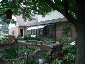 Curved eave sunroom by a garden