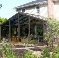 Glass cathedral sunroom with next to a garden