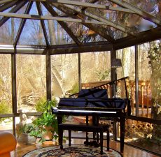 Conservatory style sunroom with a piano
