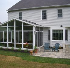 solid roof cathedral sunroom off of outdoor patio