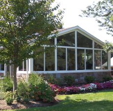 solid cathedral roof sunroom with stone lower wall