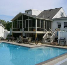 solid cathedral roof sunroom deck with stairs to pool