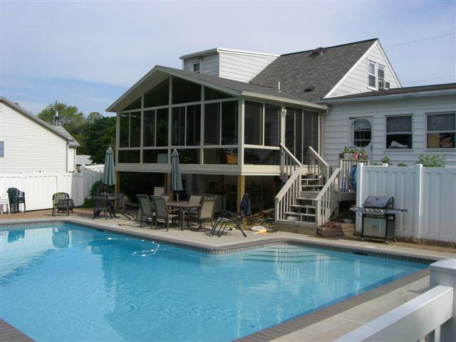 solid cathedral roof sunroom deck with stairs to pool