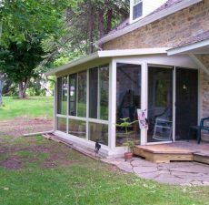 solid roof sunroom installation connected to outdoor patio