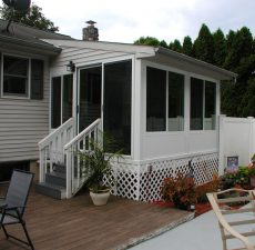 White patio enclosure that opens to a deck